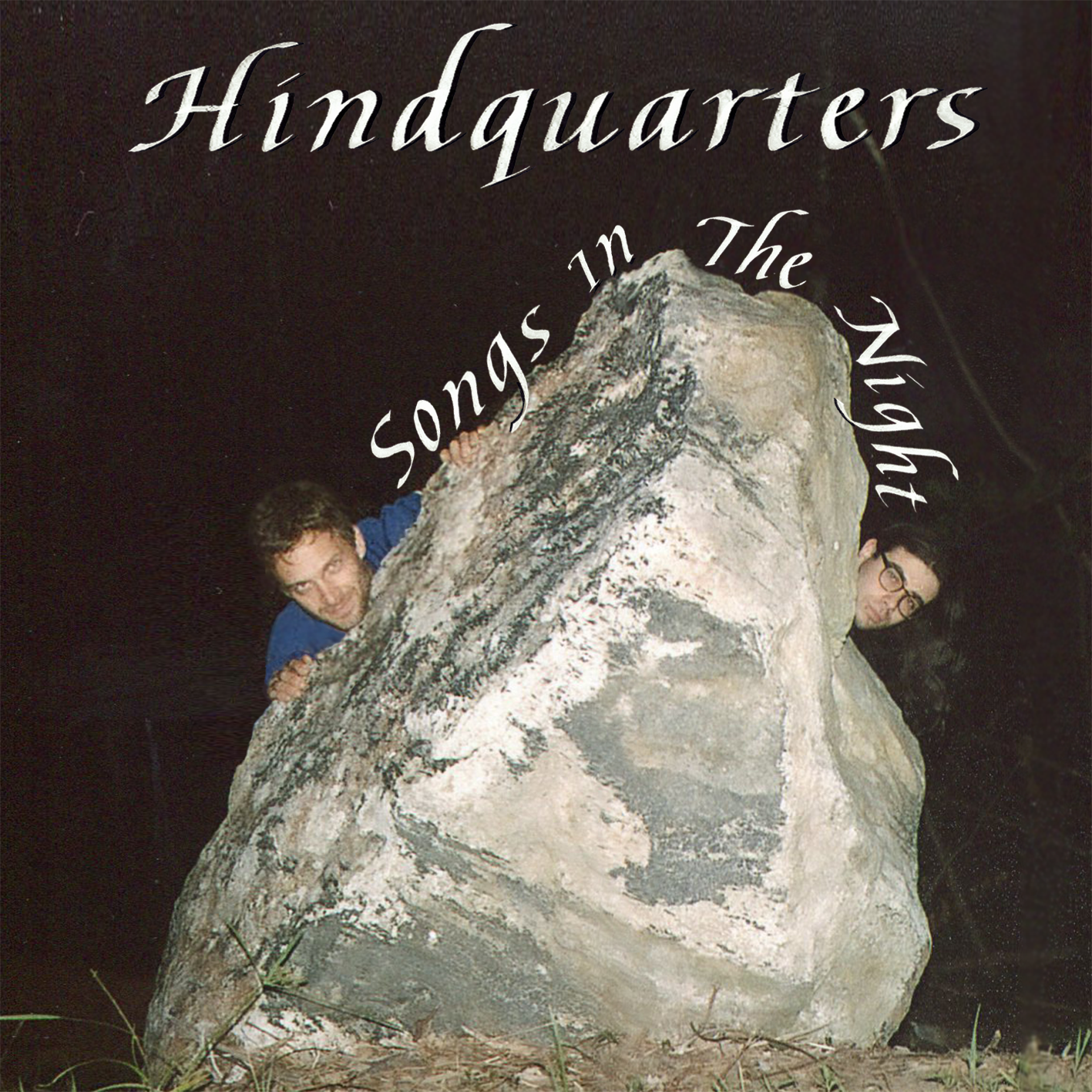 The album art for Hindquarters' Debut EP: Songs in the Night. Two men peek their heads out from the sides of a large stone.